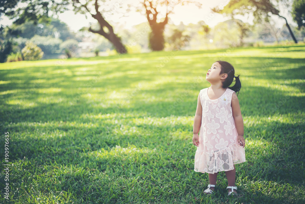 Smiling young girl standing in the park, happy time Smiling young girl standing in the park, happy time