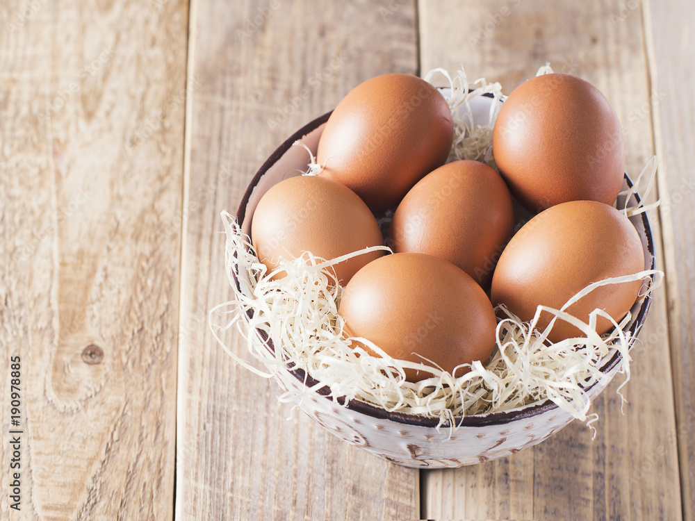 Chicken eggs in bowl on wooden table, rustic, easter theme Chicken eggs in bowl on wooden table, rustic, easter theme
