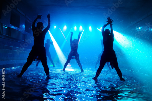 Performance on the water of a dance group against the background of club light.
