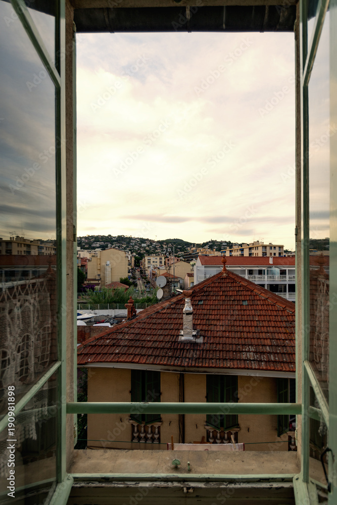 View out of a window over small mediterranean village with sunset