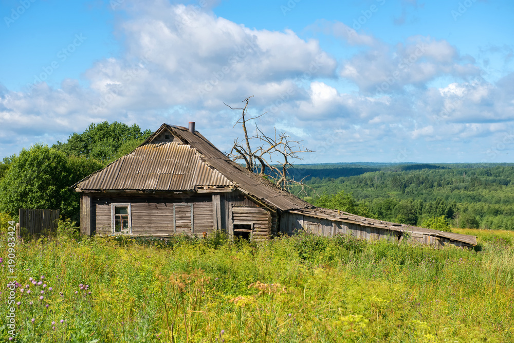 Old abandoned wooden house with green grass hills in the background Old abandoned wooden house with green grass hills in the background