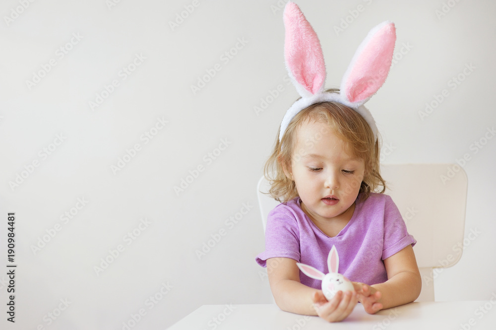 Happy Easter. The lovely girl with ears of a rabbit holds in hand a small egg Happy Easter. The lovely girl with ears of a rabbit holds in hand a small egg