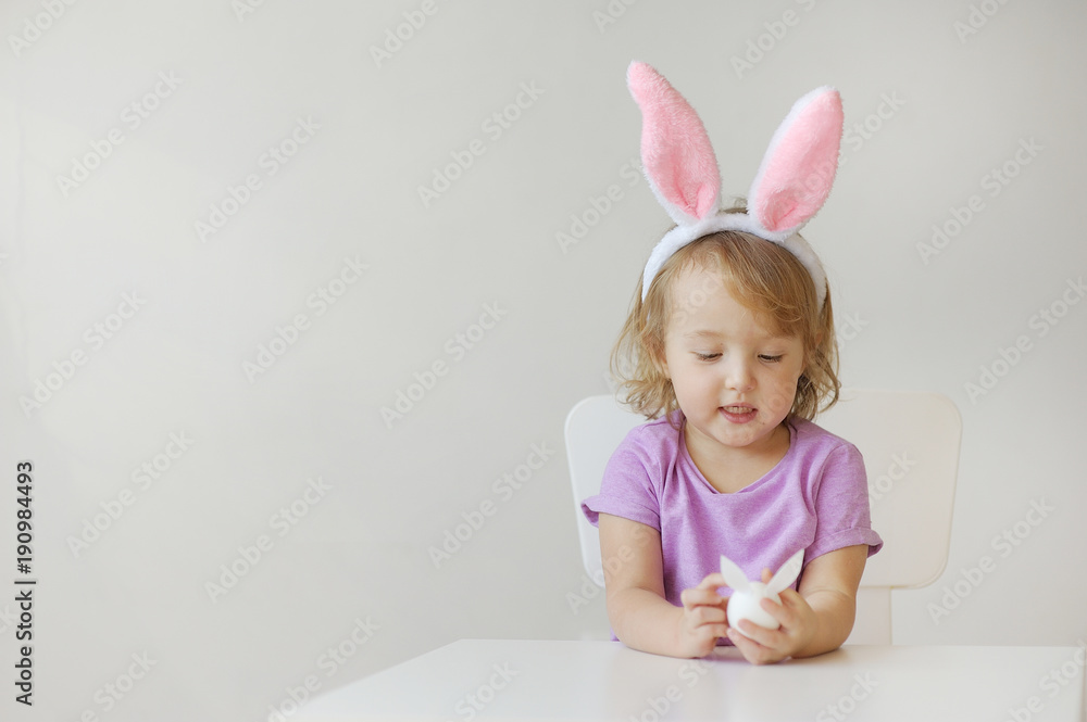 Happy Easter. The lovely girl with ears of a rabbit holds in hand a small egg Happy Easter. The lovely girl with ears of a rabbit holds in hand a small egg