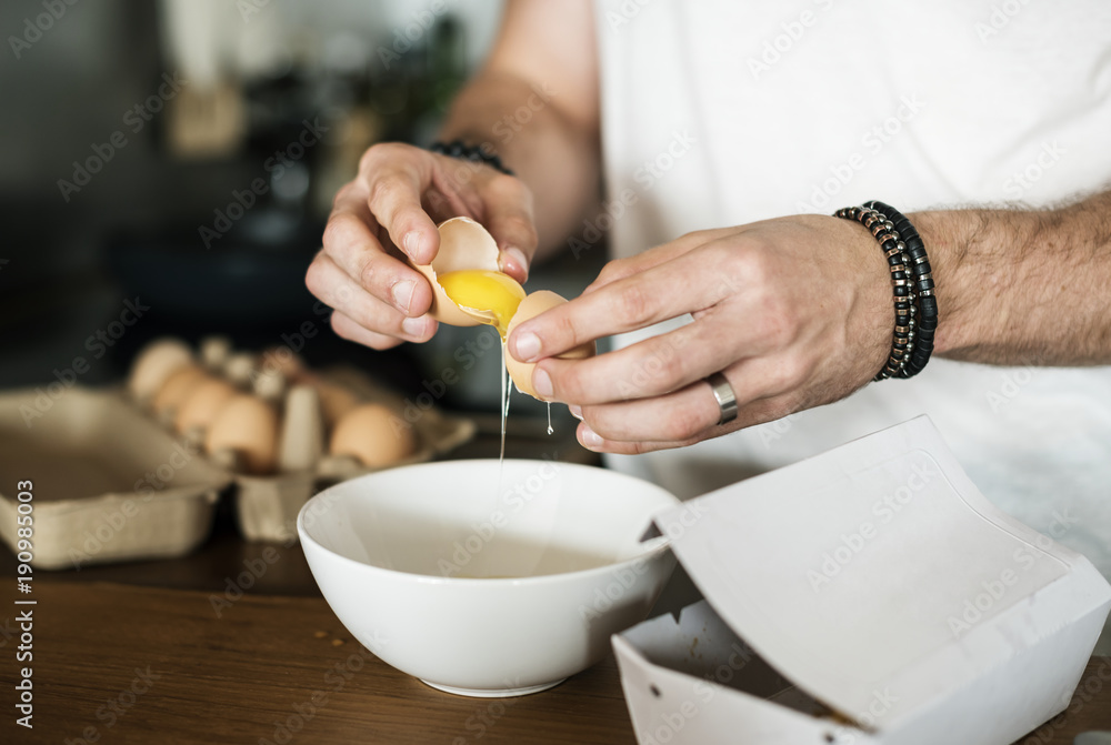 Closeup of man separating egg yolk Closeup of man separating egg yolk