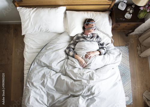 Woman sleeping with an anti-snoring mask photo