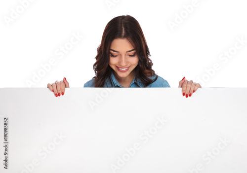 Obraz na płótnie smiling casual woman standing above a big blank board