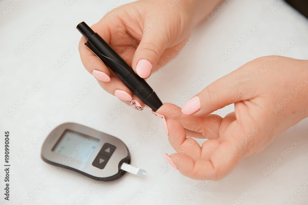 Glucometer. Woman checks blood sugar level for diabetes, insulin levels