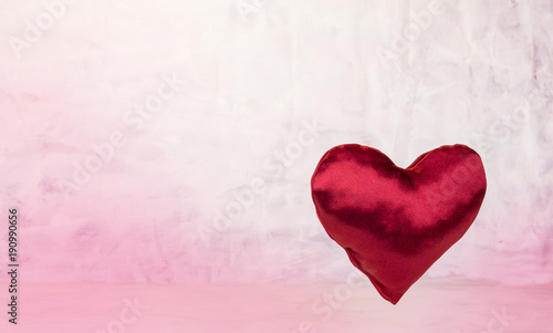 Satin heart on light red background.Valentine's Day concept