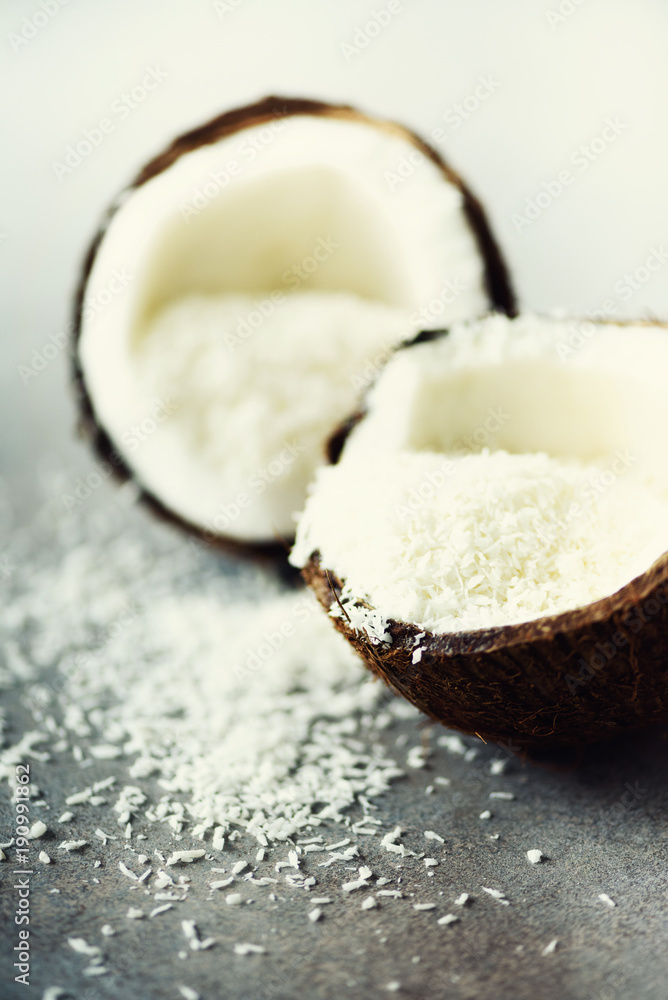 Coconut fuit halves with coconut shavings on grey concrete background. Copyspace Coconut fuit halves with coconut shavings on grey concrete background. Copyspace