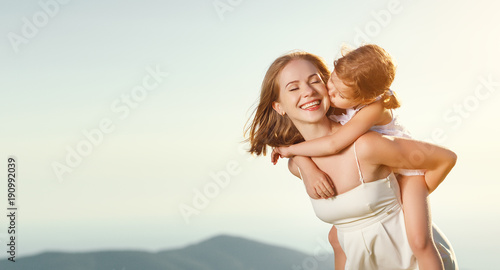 Happy family in summer outdoors. mother hug child daughter and laughing