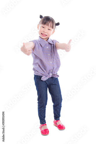Little asian girl smiling and showing thumbs up while standing over white background © gamelover