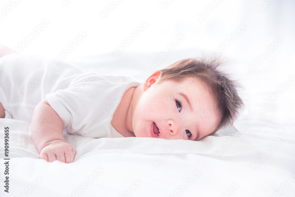 Little asian infant waking up on white bed in the morning Little asian infant waking up on white bed in the morning