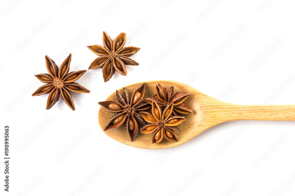 Close up the brown star anise spice in wooden spoon isolated on white background Close up the brown star anise spice in wooden spoon isolated on white background