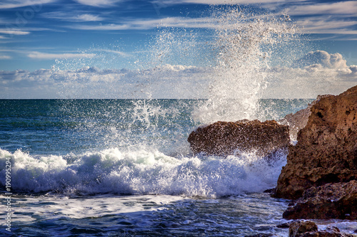 Beautiful rocky coast of the ocean, stunning beautiful landscape of the Algarve, Portugal, waves crash against the shore in splashes, travel to Europe