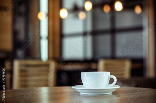 White cup of coffee at the cafe interior - vintage style effect picture