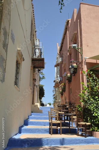 greece island krit Rethymnon street climb up with blue steps on them little brown wooden tables © жанна карасик