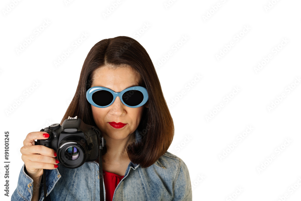 Woman in denim shirt and blue sunglasses holding a camera. Woman in denim shirt and blue sunglasses holding a camera.
