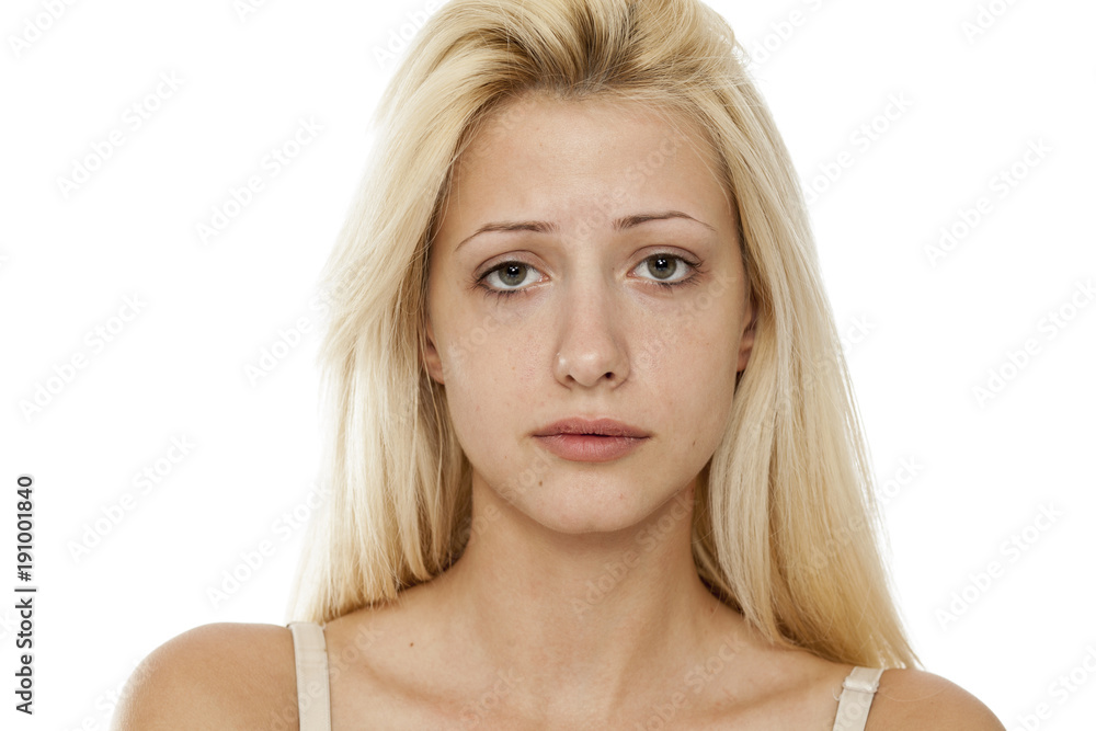 Young blonde sad woman without makeup on white background Young blonde sad woman without makeup on white background