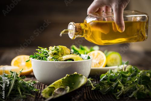 pouring olive oil to lettuce