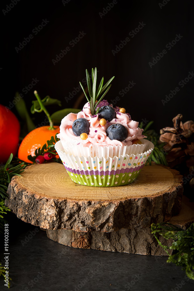 cupcakes berry and chocolate on a wooden board. Sweet dessert with tangerines. Dark background