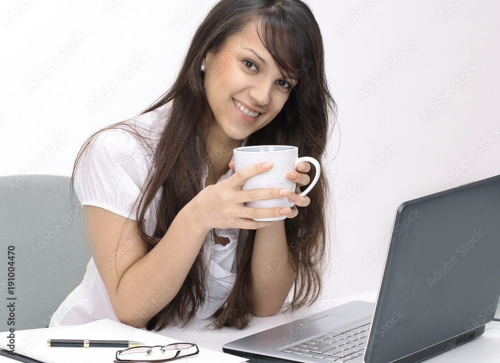 young woman with Cup of tea sitting in the workplace young woman with Cup of tea sitting in the workplace
