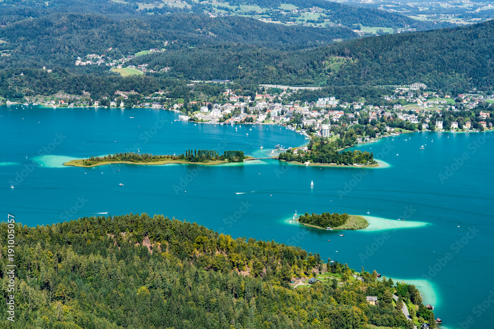 Wörthersee in Österreich Kärnten mit der Kapuzinerinsel (mittig) und dem Ort Pörtschach im Hintergrund sowie der Schlangeninsel links