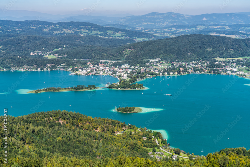 Wörthersee in Kärnten Austria mit der Kapuzinerinsel (mittig) und dem Ort Pörtschach im Hintergrund sowie der Schlangeninsel links