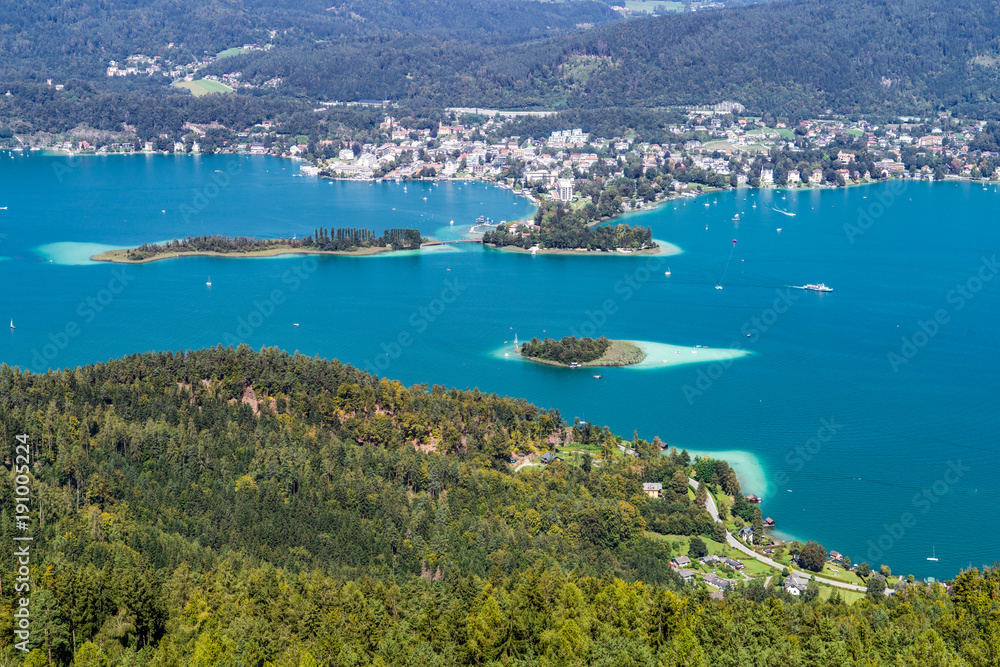 Wörthersee in Kärnten Österreich mit der Kapuzinerinsel (mittig) und dem Ort Pörtschach im Hintergrund sowie der Schlangeninsel links