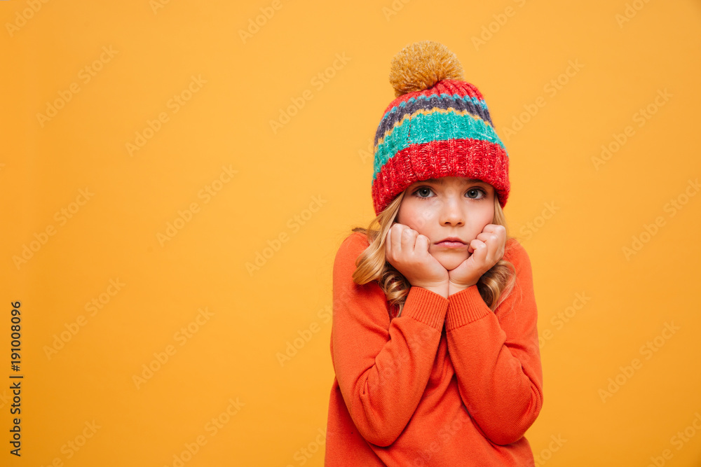 Bored girl in sweater and hat reclines on her arms Bored girl in sweater and hat reclines on her arms