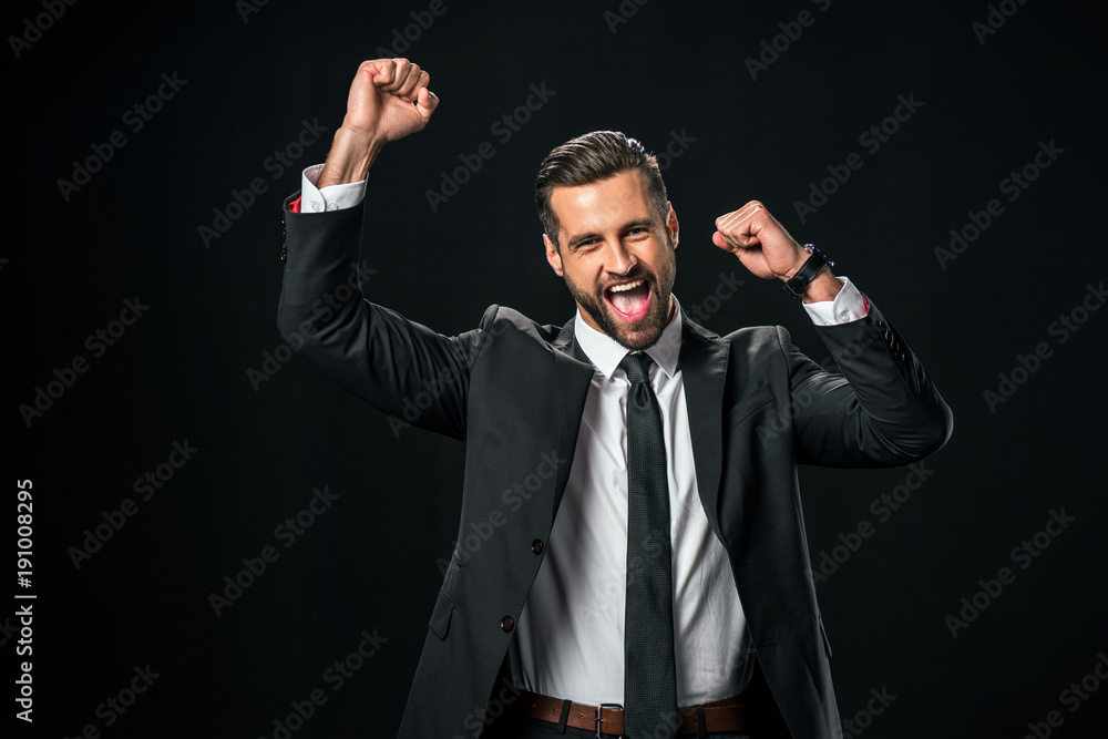 excited successful businessman yelling and celebrating isolated on black
