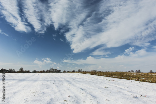 Snow-covered field and clouds in the sky