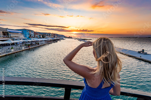 Sunset in Lefkada admired by a beautiful young woman in Lefkada Town Greece photo