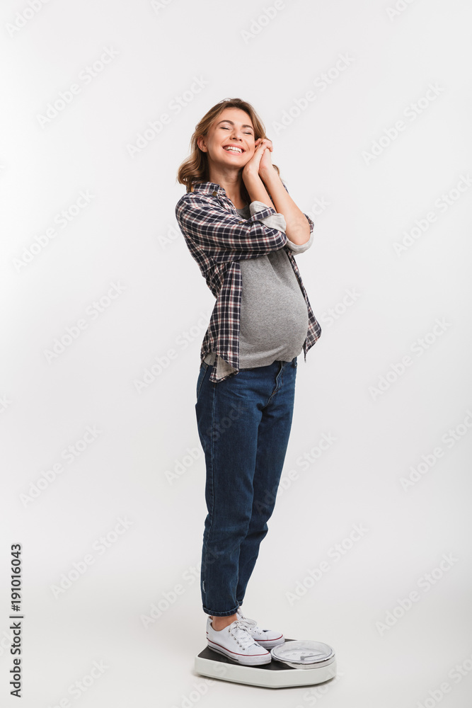 happy young pregnant woman with closed eyes standing on scales happy young pregnant woman with closed eyes standing on scales
