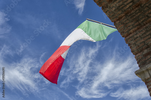 Fototapeta Naklejka Na Ścianę i Meble -  The Italian flag with clouds in the background