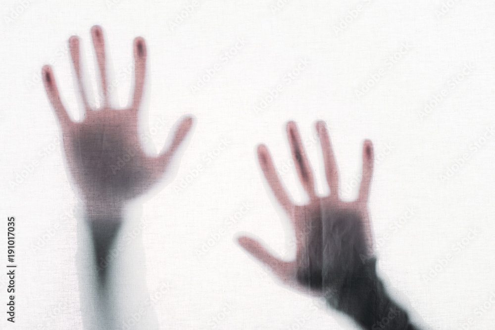 blurry silhouette of human hands touching frosted glass blurry silhouette of human hands touching frosted glass