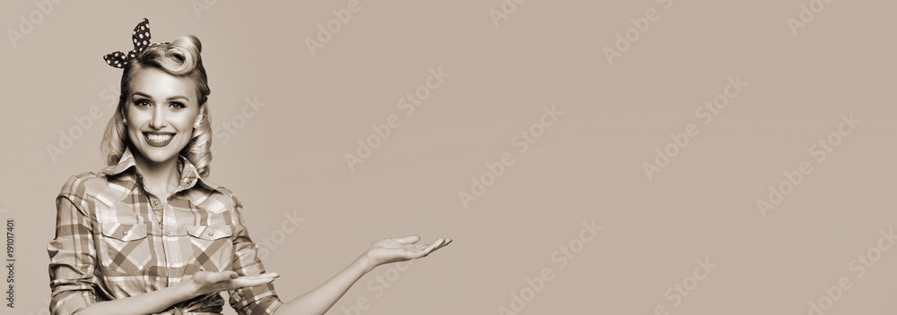 Fototapeta premium woman, dressed in pin-up style, showing something or copy space