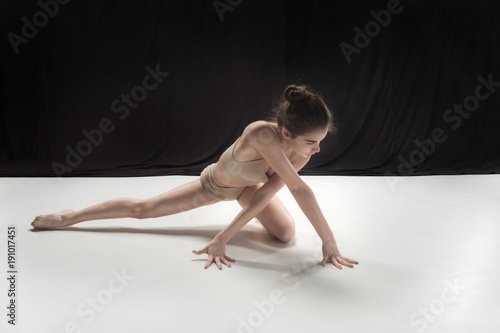 Young teen dancer on white floor background.