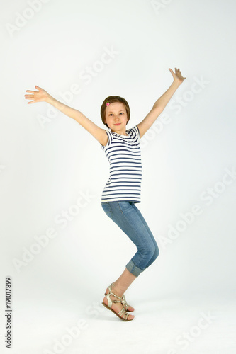 Vertical Portrait Of Jumping Little Girl. Cute Jumping Girl. Cheerful Pretty Young Girl Jumping And Holding Hands Up. 