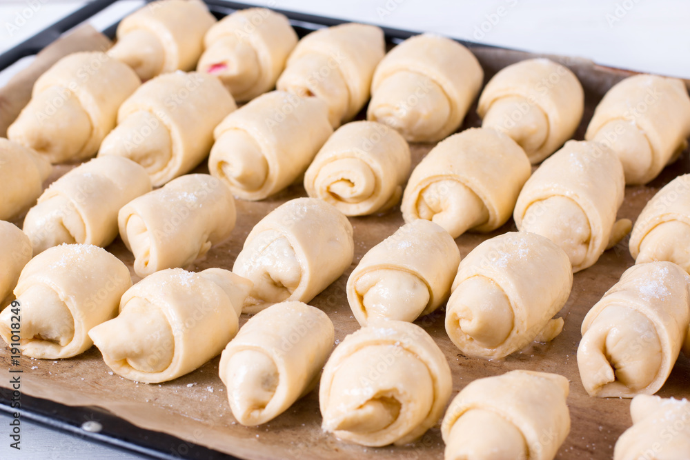 Making small homemade croissants in the kitchen on a baking sheet Making small homemade croissants in the kitchen on a baking sheet