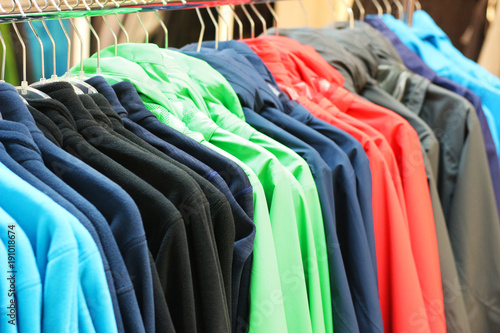 row of multi colored outdoor jackets in a store
