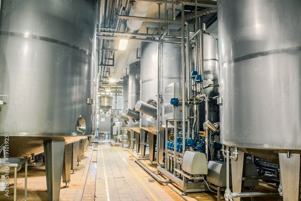 Large stainless steel barrels connected by pipes in the factory industry Large stainless steel barrels connected by pipes in the factory industry