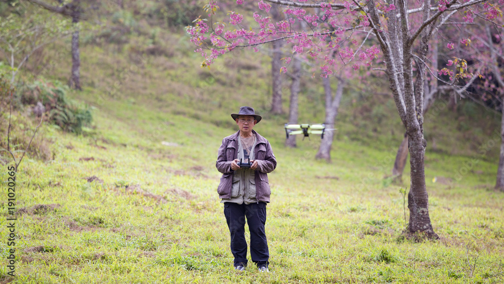 Senior pilot photographer with drone control monitor in shoot