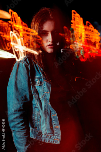 Attractive brunette woman posing in mixed light technique at the night avenue