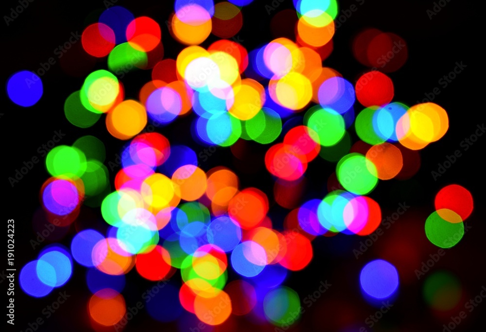 Colorful blurred bokeh lights on black background.