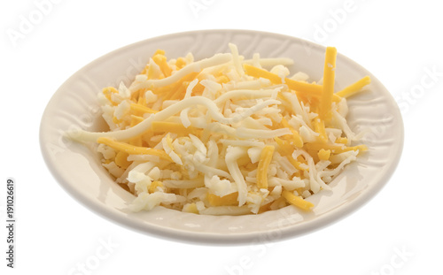 A blend of mozzarella and cheddar cheeses for pizza topping in a small bowl isolated on a white background.