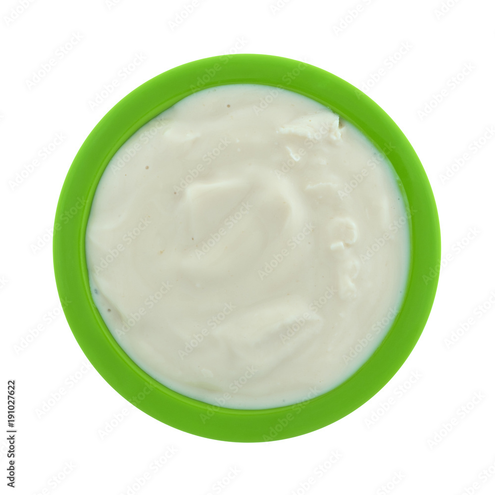 Top view of a small green bowl filled with caramel yogurt isolated on a white background. Top view of a small green bowl filled with caramel yogurt isolated on a white background.