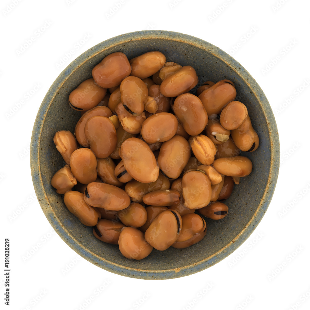 Top view of canned fava beans in an old stoneware bowl isolated on a white background. Top view of canned fava beans in an old stoneware bowl isolated on a white background.