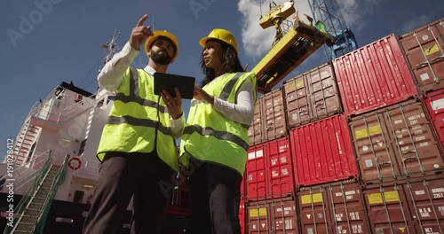 An attractive businesswoman and a manager doing inspections at a busy dock. Shot on RED Epic.