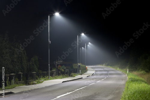 empty night street on small village with modern street lights photo