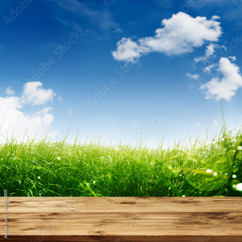 Spring meadow with wooden table and blue sky